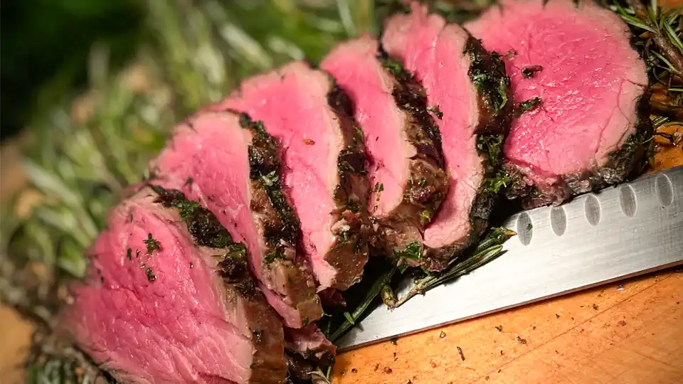 Sliced beef tenderloin displayed on a cutting board at a social event in phoenix